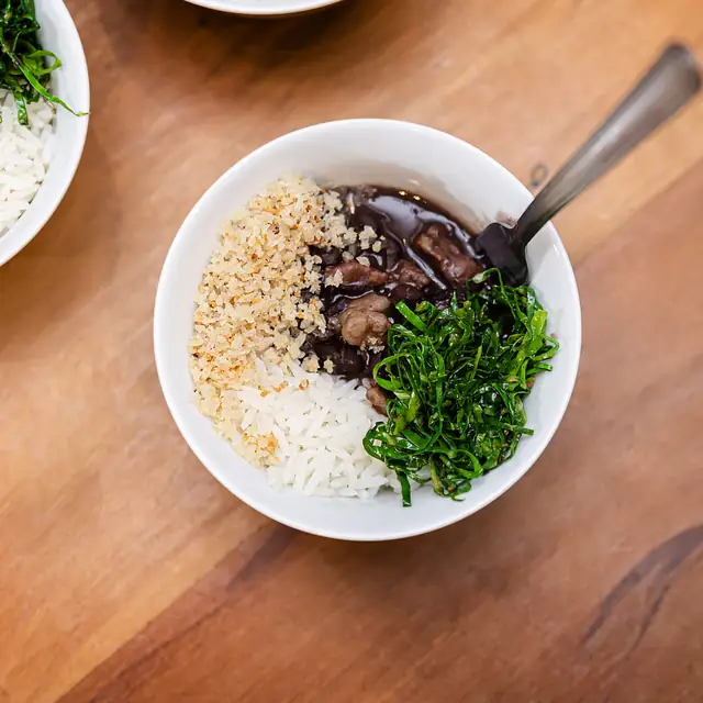 Feijoadinha com arroz, couve e farofa em cumbucas